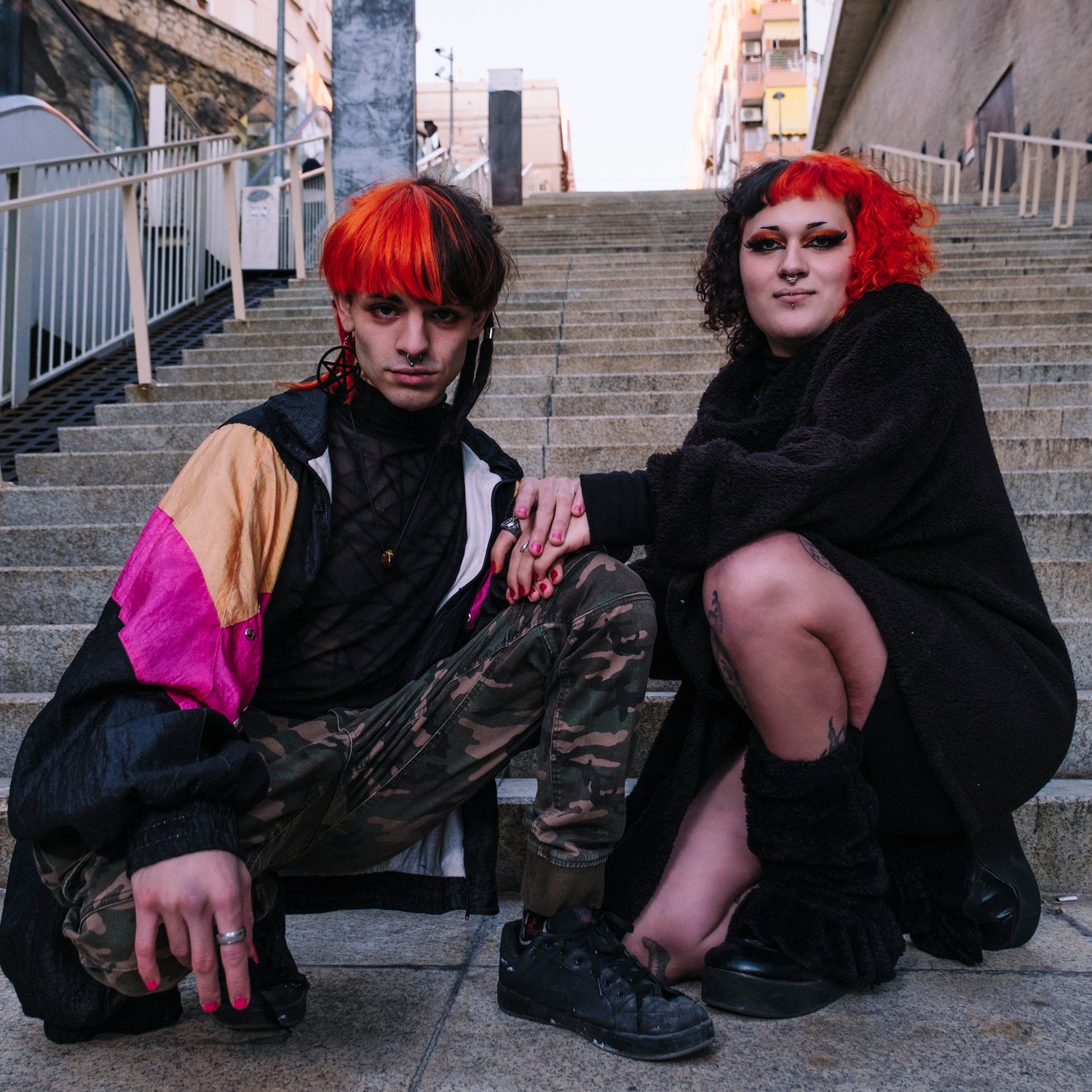 Two people with red hair sitting on stone steps outdoors.